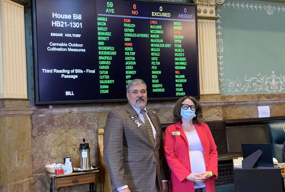 Representative Richard Holtorf and Majority Leader Daneya Esgar stand in front of a vote tally board.
