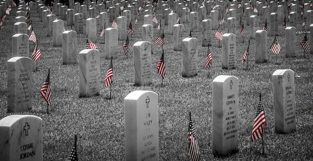 An image of military gravestones with small flags by each one.